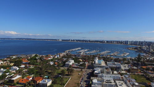 High angle view of townscape by sea against sky