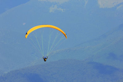 High angle view of man paragliding above mountains