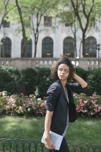 Portrait of woman standing against trees