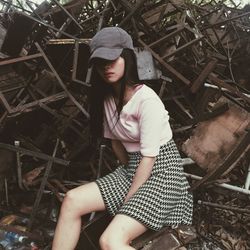 Young woman sitting against metal scrap