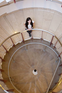 Low angle view beautiful young women lonely on spiral staircase with a foucault pendulum experiment