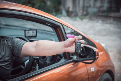 Midsection of man holding key while sitting in car