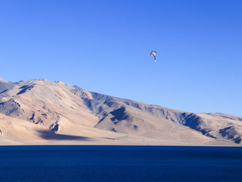 Scenic view of snowcapped mountains against clear blue sky