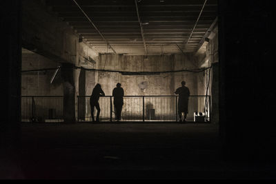 Rear view of silhouette people standing in abandoned building