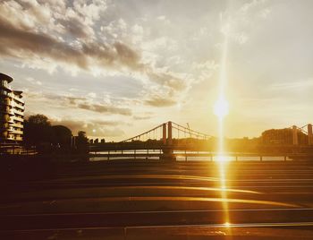 Bridge over city against sky during sunset