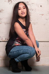 Portrait of young woman sitting on floor