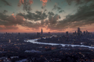 High angle view of illuminated cityscape against sky during sunset