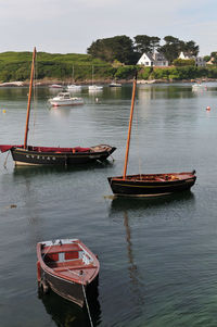 Sailboat moored on lake against sky