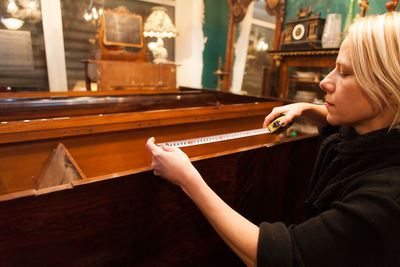 Woman measuring furniture at store