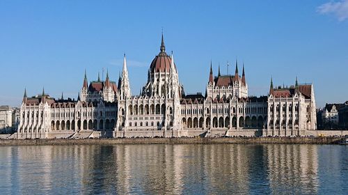 View of buildings in city against clear blue sky