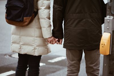 Rear view of friends standing on street