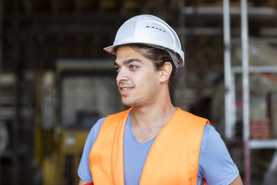 Young construction engineer with helmet working outside