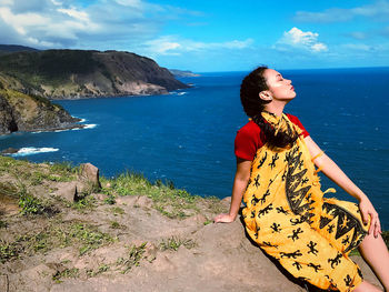 Young woman on beach against sky