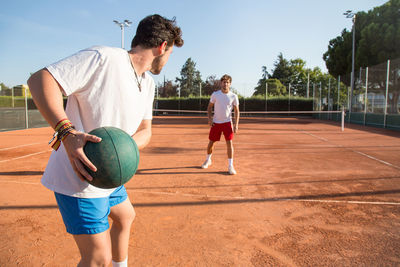 Tennis players exercising with medicine ball at court