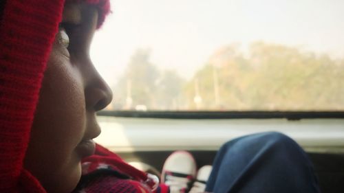 Close-up of girl sitting by window