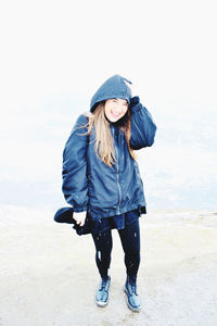 Full length of woman standing on snow against sky