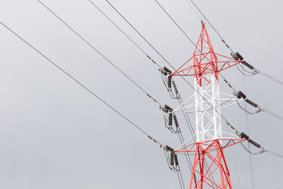 Low angle view of electricity pylon against clear sky