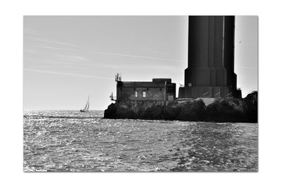 Sailboat by sea against clear sky