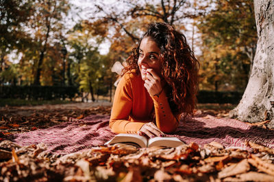 Young woman lying on book