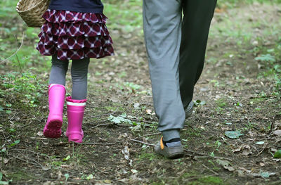 Low section of father and girl standing on field