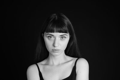 Portrait of woman against black background