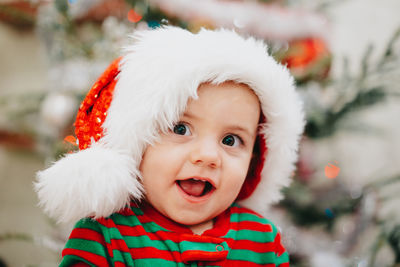 Cute baby boy looking away while wearing santa hat