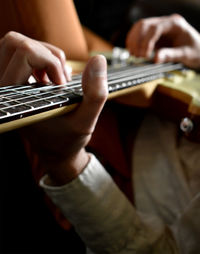 Cropped hand of man playing electric guitar