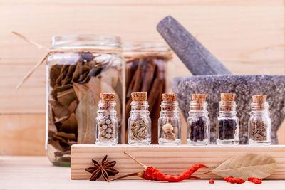 Close-up of dry and fresh herbs in jar on table