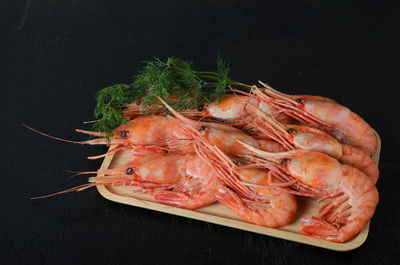 Close-up of meat in plate against black background