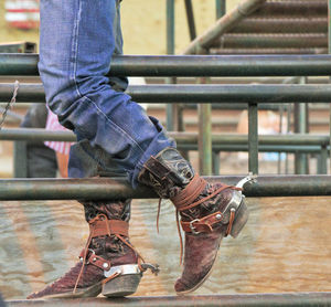 Low section of man standing on railing