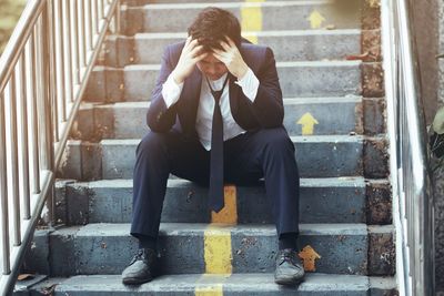 Full length of man sitting on staircase