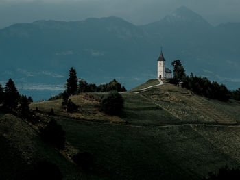 Scenic view of building and mountains against sky