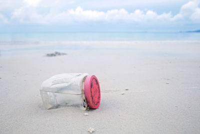 Pink umbrella on beach against sky