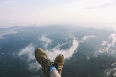 Low section of man on mountain against sky