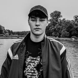 Portrait of young man standing against trees