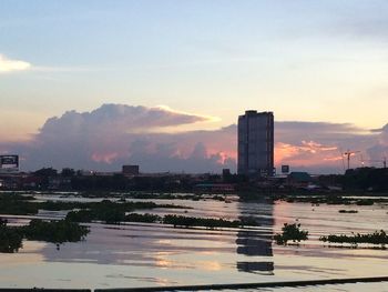 Illuminated cityscape against sky during sunset