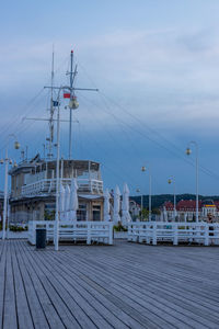 Sailboats moored at harbor against sky