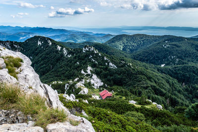 Looking on schlossers mountain hut from veliki risnjak peak. scenic view of mountains against sky