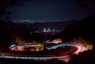 High angle view of illuminated city against sky at night