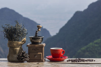 Tea cup on table against mountains