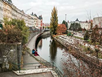 Bridge over river in city against sky