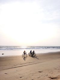 Bicycles on beach against sky