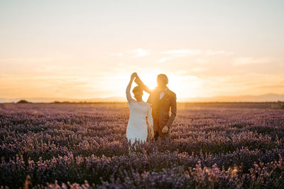 People on field against sky during sunset