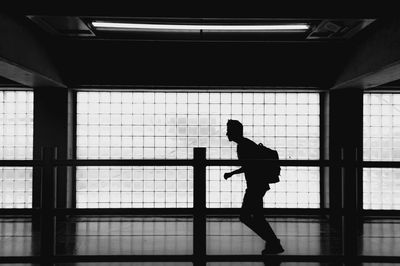 Side view of silhouette woman standing against window