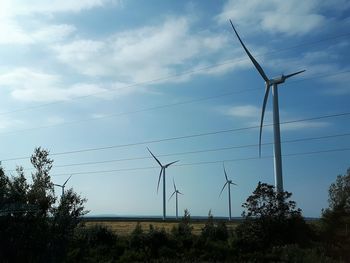 Low angle view of windmill on field against sky