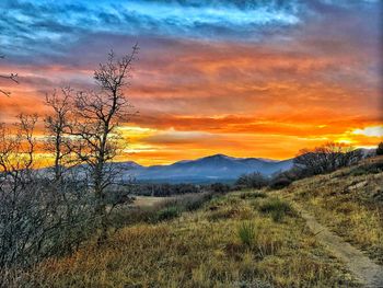 Scenic view of silhouette mountains against orange sky