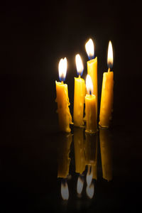 Close-up of lit candles in the dark