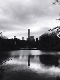 City at waterfront against cloudy sky