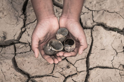 Close-up of man holding hand in mud