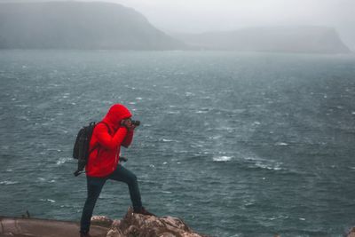 Man in sea against mountain